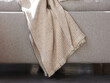 © Miquel Llonch/Stocksy - Hanging blanket on couch.