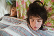 © Maria Manco/Stocksy - High angle view of siblings sleeping on bed at home
