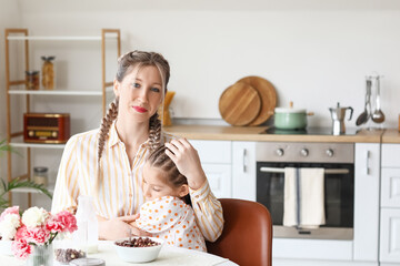 Canvas Print - Little girl and her mother having breakfast in kitchen