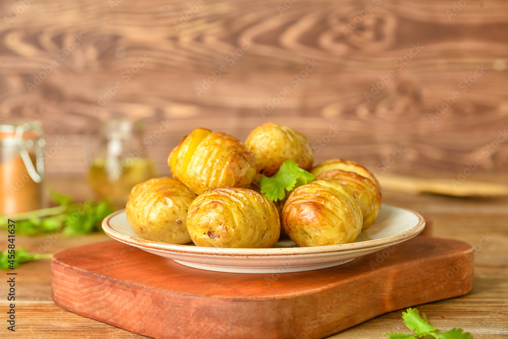 Plate with tasty baked potato on table