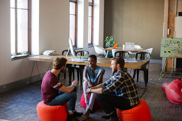 Wall Mural - Casual business people working on bean bag chairs in open office