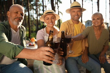 Mature people drinking at barbecue party on summer day