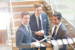 © KOTO - Businessmen with digital tablet and coffee talking on stairs