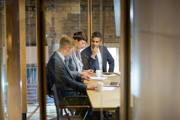 Business people talking at laptop in conference room