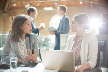 Poster - Businesswomen talking and working at laptop in office