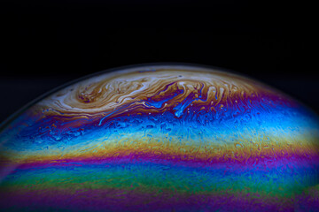Wall Mural - macro picture of half soap bubble on black ground look like abstract psychedelic color planet in spa