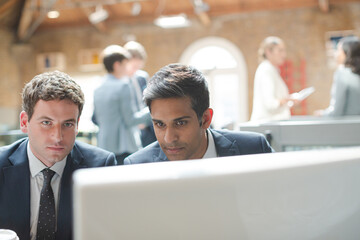 Businessmen working at computer in conference room