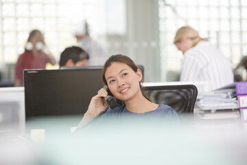 Wall Mural - Smiling businesswoman talking on cell phone