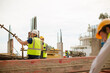 © KOTO - Construction worker engineer reviewing blueprints at highrise construction site