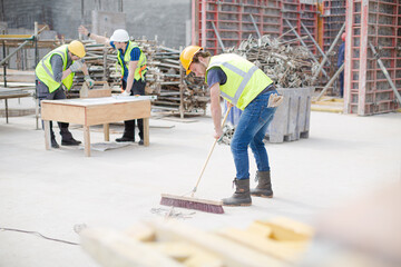 Construction worker sweeping at construction site