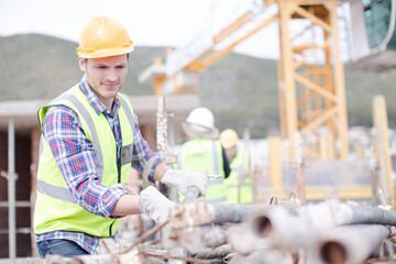 Poster - Construction worker carrying metal bar at construction site