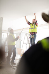 Wall Mural - Construction worker on ladder at construction site