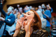 Smiling, enthusiastic woman cheering in audience