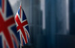 Small flags of United Kingdom on a blurry background of the city