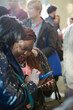 Smiling businesswomen using smart phone in conference audience