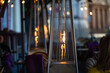 blurred photo of street cafe terrace decorated with flame heate, evening street lights