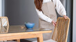© Farknot Architect - A woman  preparing and setting dining table and chair at home