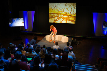 Male speaker on stage talking to audience