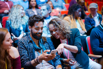 Poster - Man and woman with smart phone in conference audience