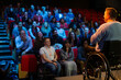 © KOTO - Speaker in wheelchair on stage talking to conference audience