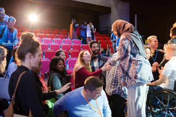 Female speaker in hijab on stage talking to audience