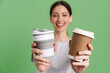 © Drobot Dean - Young brunette woman smiling while showing takeaway cups