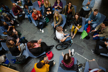 Wall Mural - Attentive audience listening to female speaker in wheelchair