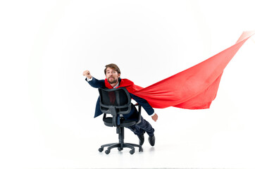 Wall Mural - business man in a suit rides in a chair with a red cloak superhero manager