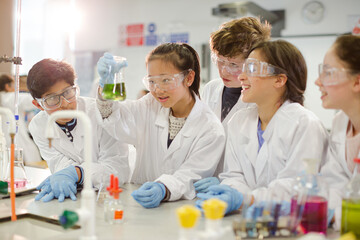 Wall Mural - curious students conducting scientific experiment, examining liquid in beaker in laboratory classroo