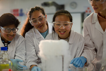Wall Mural - female teacher and students watching scientific experiment chemical reaction in laboratory classroom