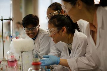Wall Mural - female teacher and students watching scientific experiment chemical reaction in laboratory classroom