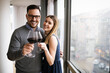 Cheerful happy couple in love drinking wine and having romantic date