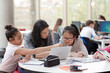 © KOTO - Female teacher and girl students using laptop at table