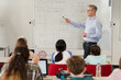 © KOTO - Male teacher leading lesson at whiteboard in classroom
