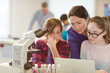© KOTO - Female teacher and girl students using microscope and laptop, conducting scientific experiment in laboratory classroom