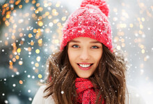People, Season And Christmas Concept - Portrait Of Happy Smiling Teenage Girl Or Young Woman Outdoors In Winter Park With Festive Lights On Background