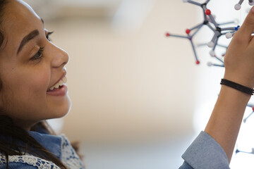 Wall Mural - curious girl student examining molecular structure