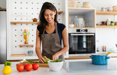 Beautiful young woman cooking in the kitchen. Healthy, organic, food concept