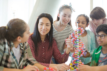 Wall Mural - female teacher and students examining dna model in classroom