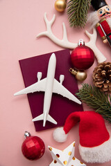 Wall Mural - Festive christmas travel background. Airplane with passport and seasonal decorations