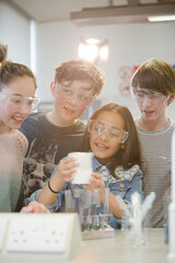 Wall Mural - curious, smiling students watching chemical reaction, conducting scientific experiment in laboratory