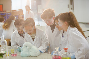 Wall Mural - surprised students conducting scientific experiment, watching chemical reaction in classroom laborat