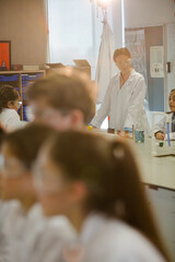 Wall Mural - female teacher and students conducting scientific experiment in laboratory classroom