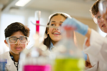 Wall Mural - students examining liquid in test tube, conducting scientific experiment in laboratory classroom