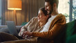 © Gorodenkoff - Young Couple Use Laptop Computer, while Sitting on a Couch in the Cozy Stylish Apartment. Boyfriend and Girlfriend Shopping on Internet, Using Social Media, Watching Funny Videos and Streaming Service