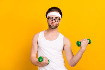 Poster - Portrait of attractive funky guy nerd doing work out muscles development isolated over bright yellow color background