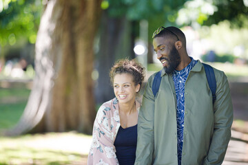 Wall Mural - Young couple holding hands, walking in park