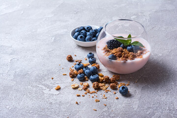 Wall Mural - Yogurt dessert with berries, granola and mint in glass