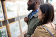 © KOTO - Young couple browsing real estate listings at storefront