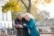 © KOTO - Senior couple with bicycles traveling, looking at guidebook along autumn river